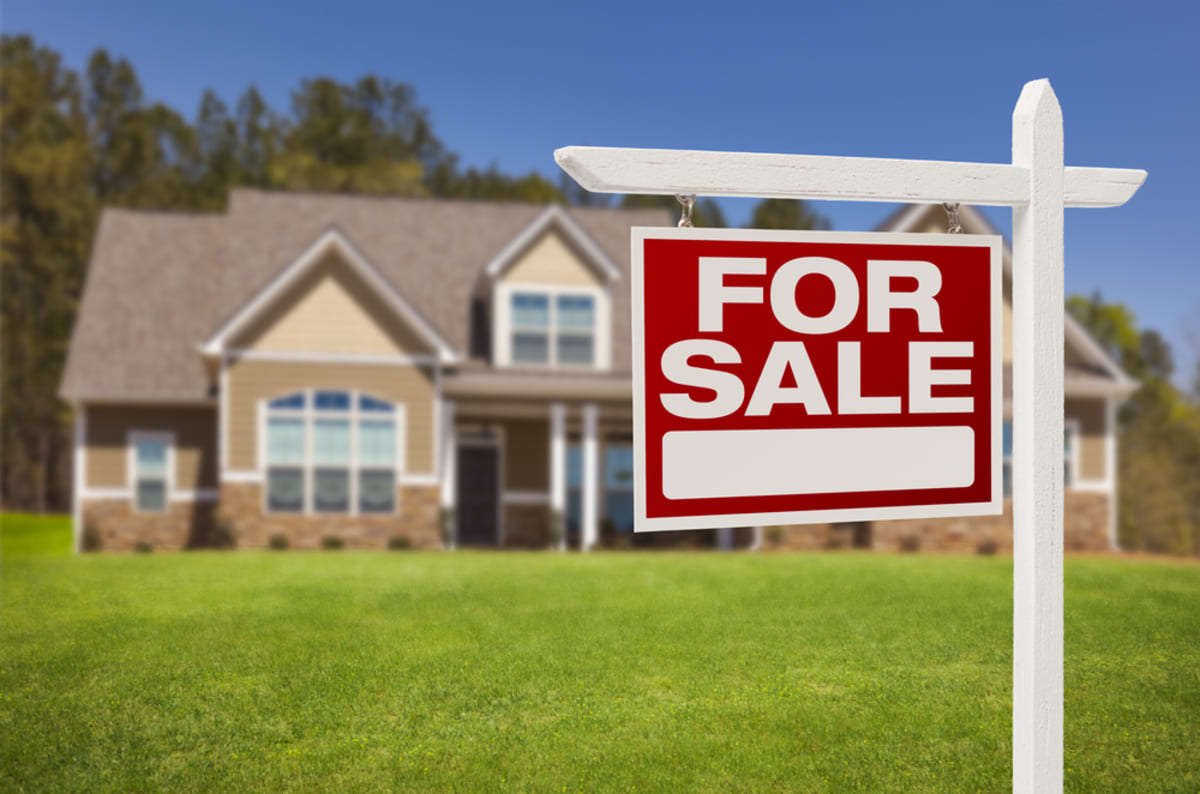 A For Sale sign in front of a home, cash for houses concept