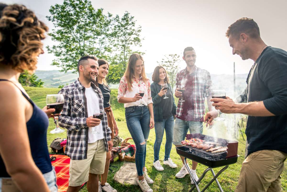 Group of young happy friends having pic-nic outdoors