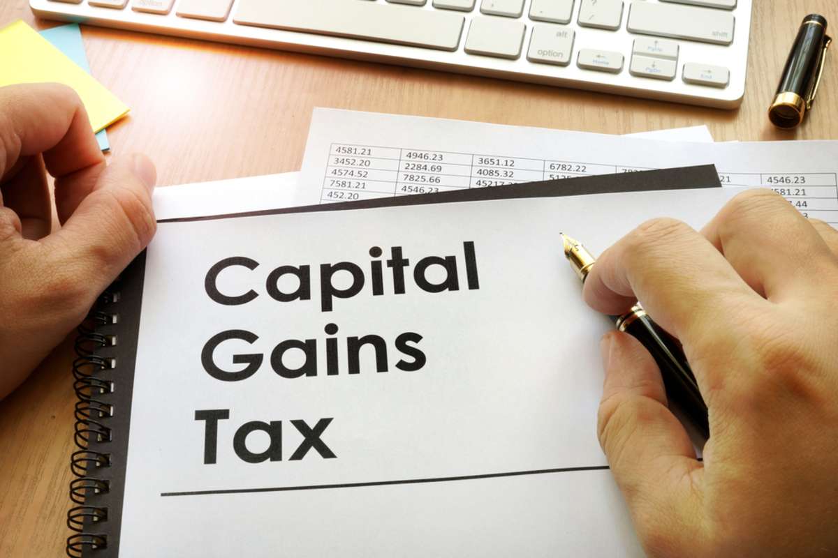 Hands holding documents with title capital gains tax CGT