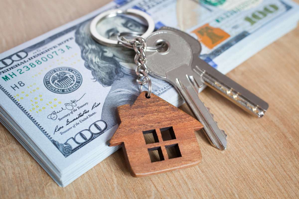 House keys sit on a stack of cash after a seller finds a company to buy my house fast