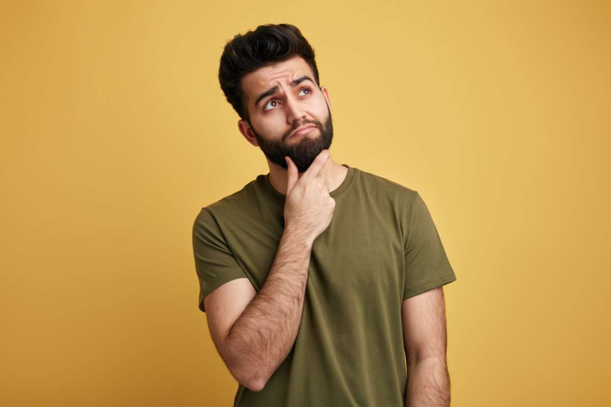 A man contemplates a question, wondering if we buy houses Minneapolis companies are legit. 