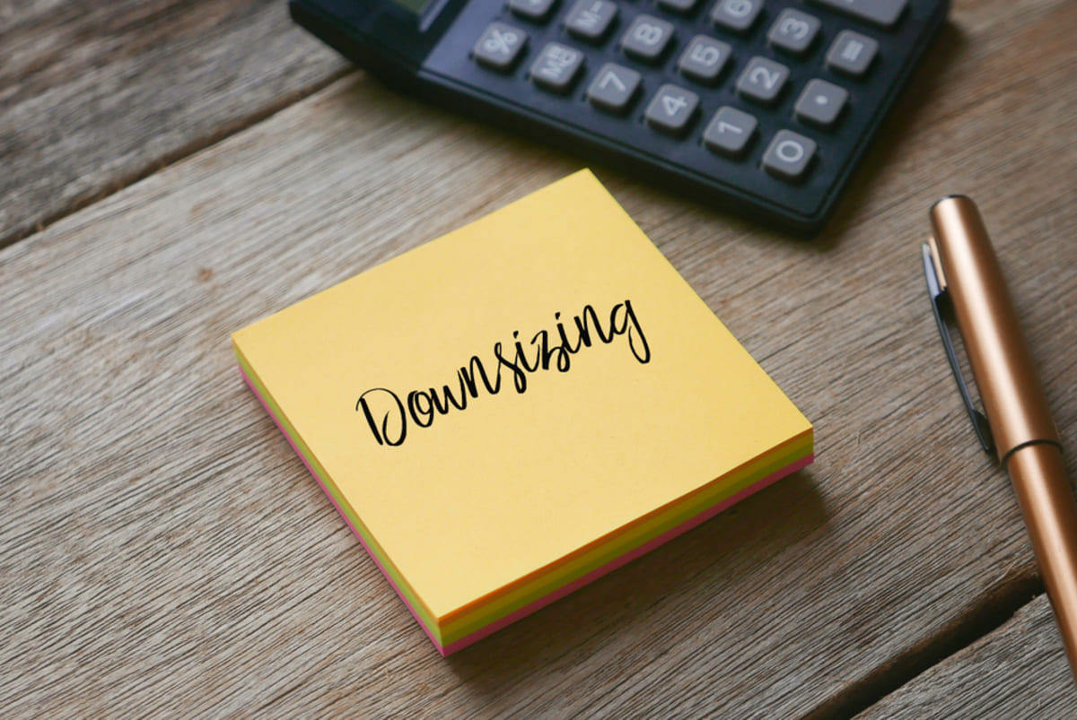 Downsizing written on a yellow notepad, downsizing your home for retirement concept