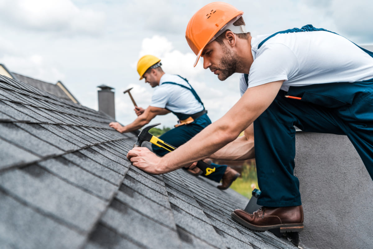 Men fixing a roof, home repairs to make before selling concept