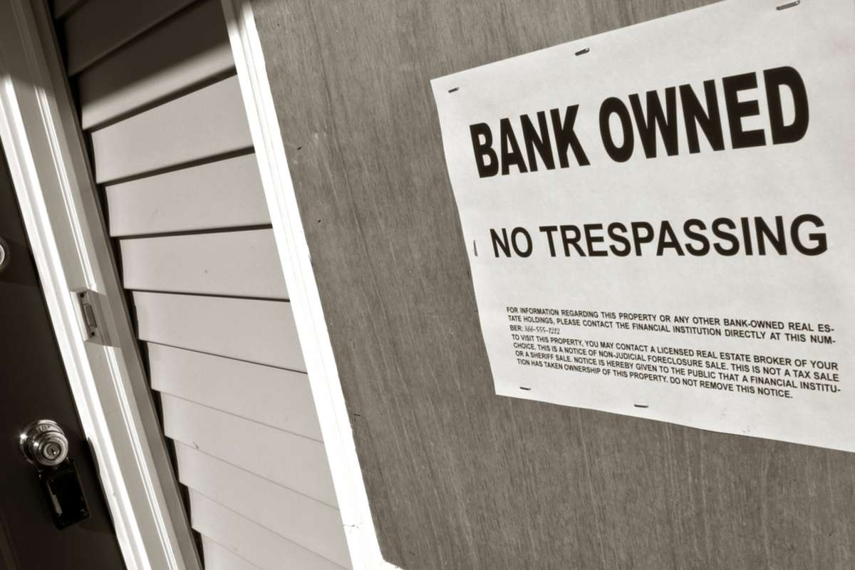 Bank Owned sign on a house, cash for my house distressed property concept